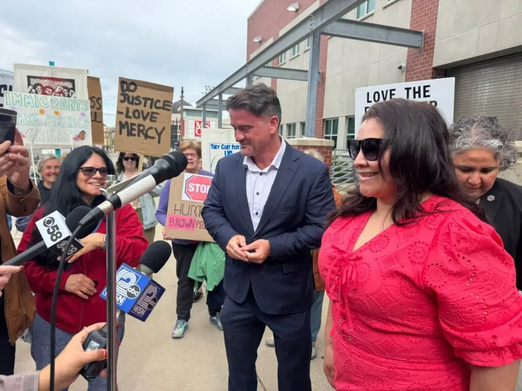 People speaking to reporters at immigration rally
